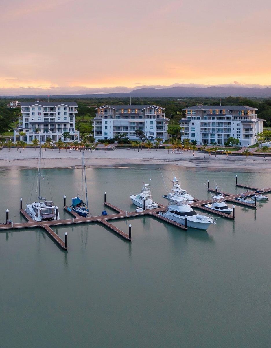 Marina Village en Buenaventura: puerto deportivo y edificios frente a la playa al atardecer